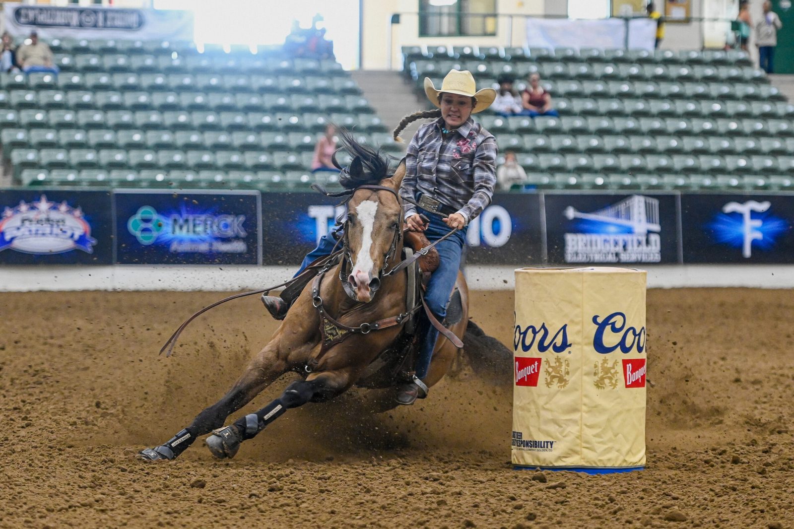 Amazona contornando um tambor numa prova de barrel racing