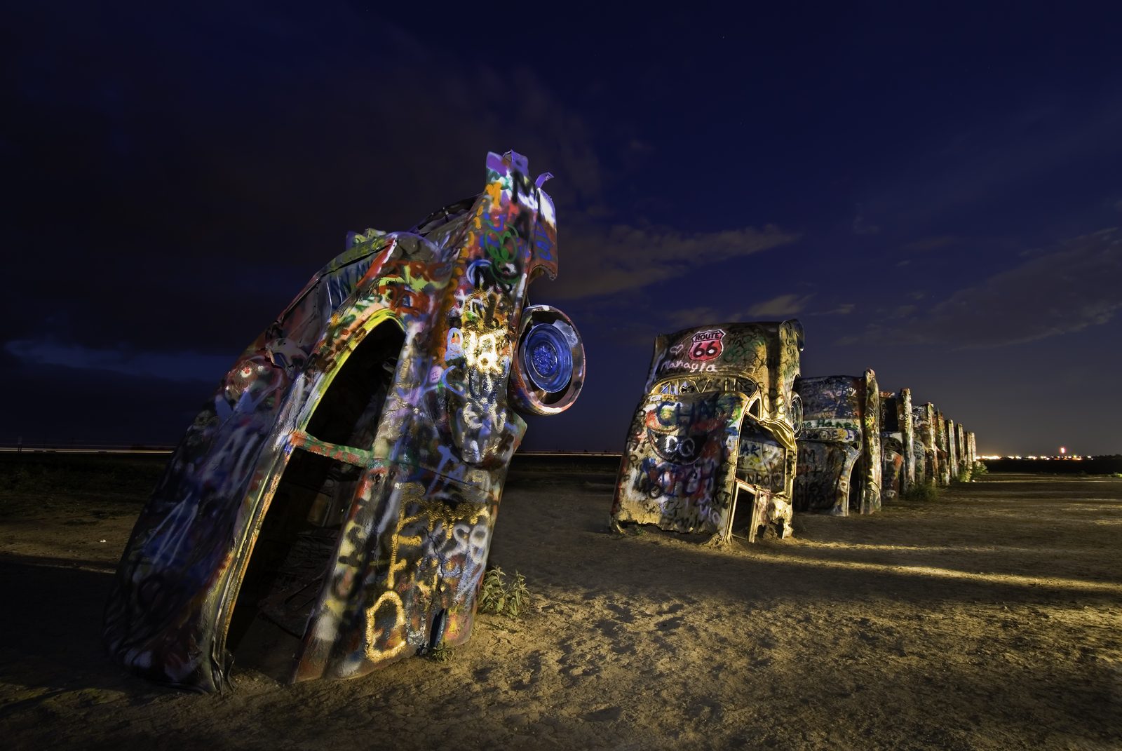 Carros grafitados enterrados no Cadillac Ranch, à noite